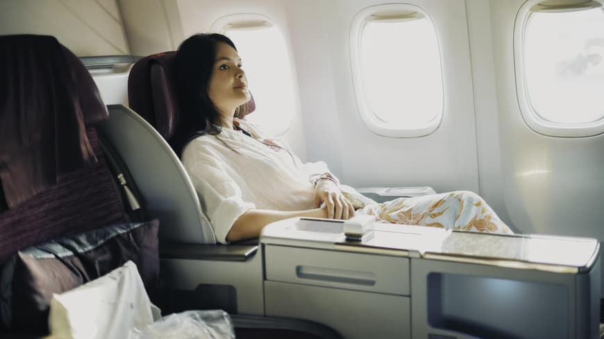 Frau in erster Klasse eines Flugzeuges