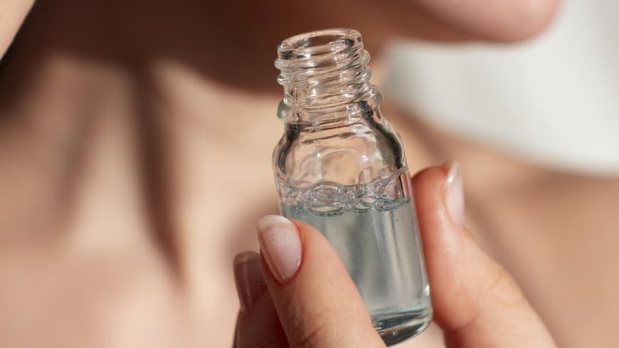Frau trägt Hautpflege-Serum auf