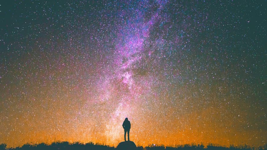 Frau steht unter Sternenhimmel