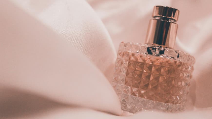 Parfum Flakon auf einem Tuch als Hintergrund