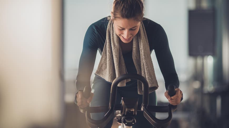 Frau fährt auf einem Indoor-Fahrrad.