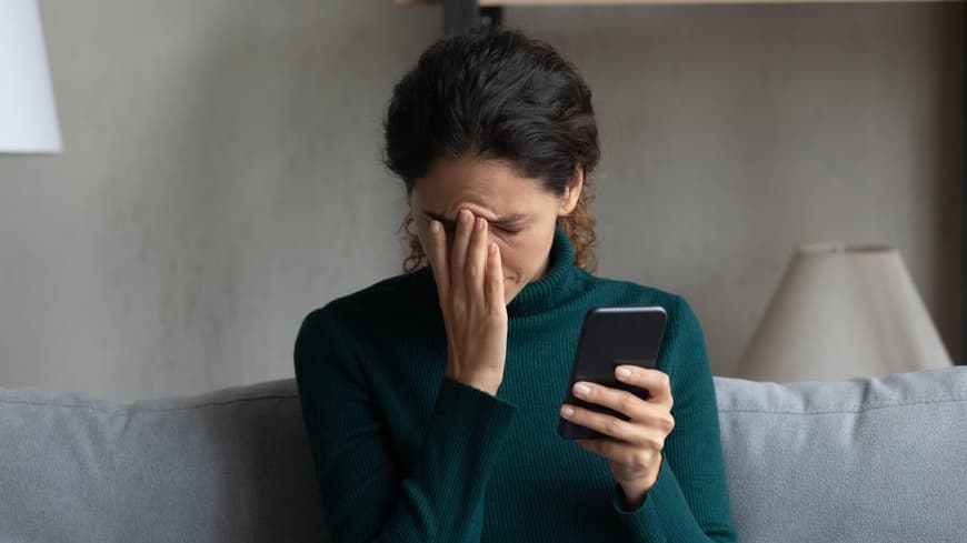 Frau verzweifelt am Smartphone
