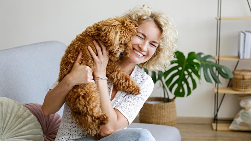 Frau kuschelt mit einem Hund.
