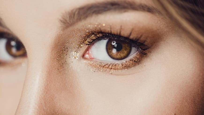 Frau trägt ein glitzerndes Augen-Make-up.