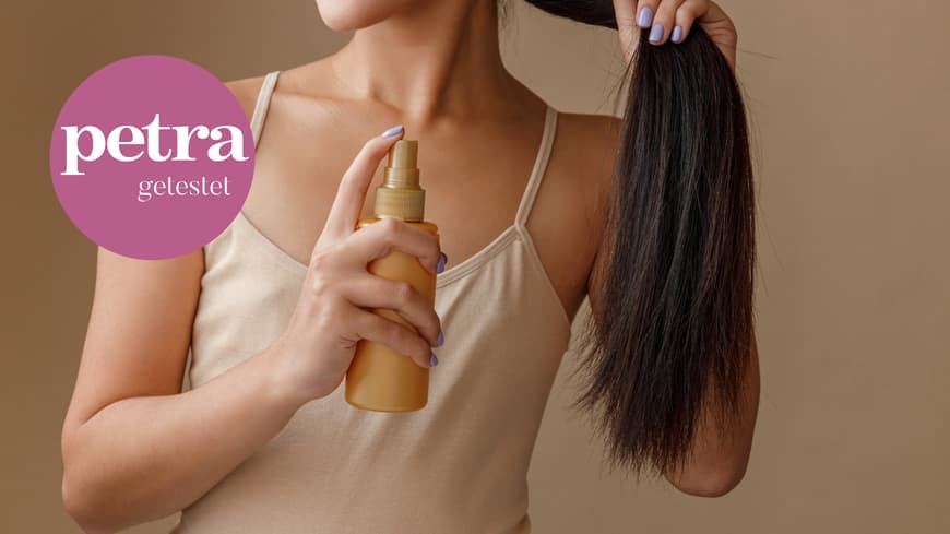Frau sprüht Haarspray auf Längen
