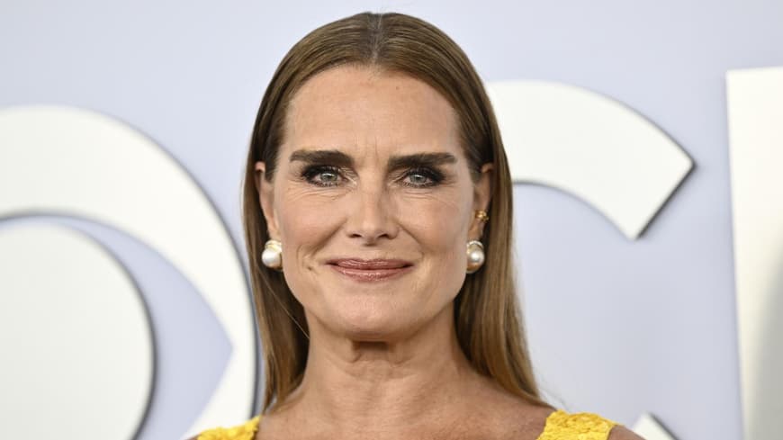 Brooke Shields mit Perlen Ohrringen und einem gelben Kleid.