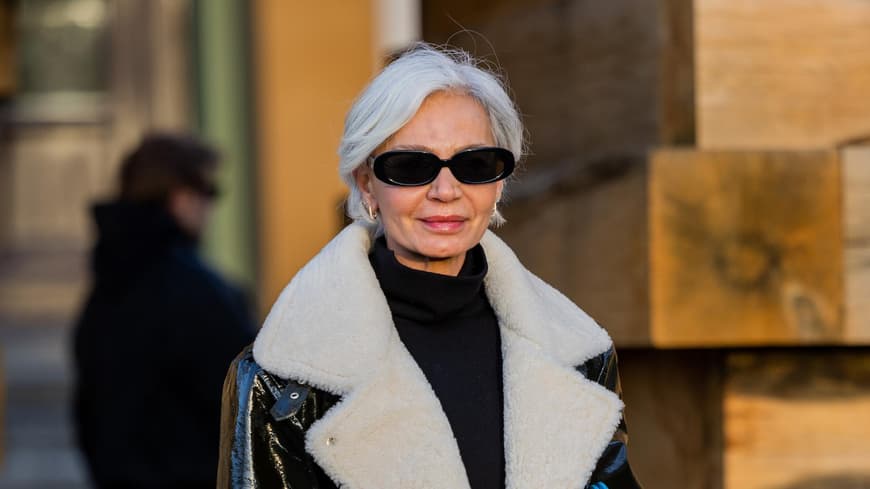 Frau mit kurzen grauen Haaren und einer Sonnenbrille.
