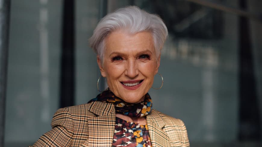 Maye Musk mit einem kurzen Haarschnitt und karierten Anzug.