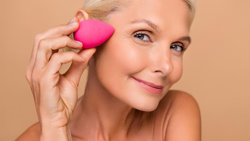 Frau mit Verblender, um Concealer aufzutragen