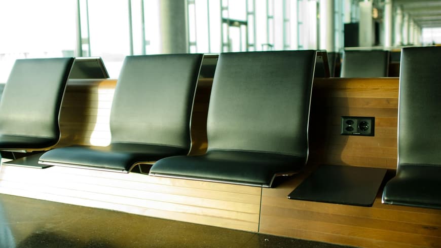 Sitzbänke mit schwarzen Polstern am Flughafen.