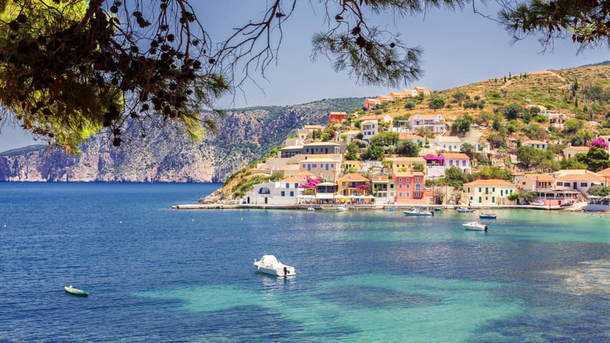 Die Küste von Kefalonia mit bunten Häusern und Booten auf dem Wasser.