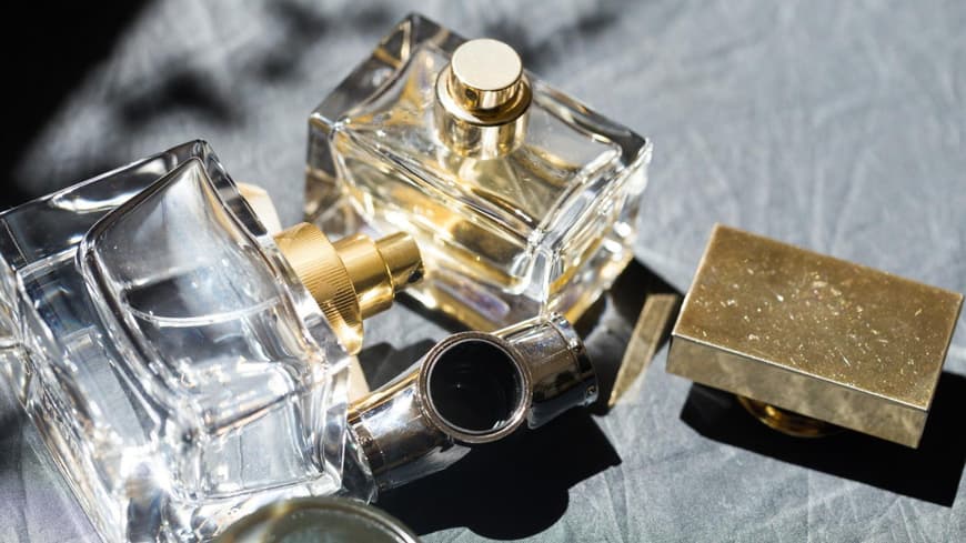 Parfum Flakons liegen auf einem grauen Hintergrund.