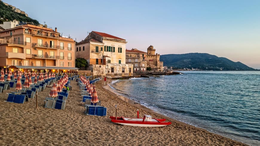 Strand von Cilento mit Häusern, Liegen und Sonnenschirmen.