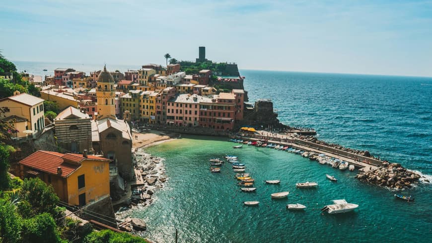 Die Küste von Vernazza in der Toskana mit bunten Häusern und Booten im Wasser.