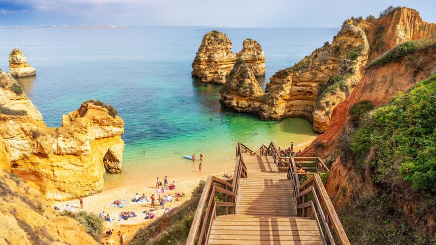 Ein Blick auf eine Holztreppe, die zum Camilo Beach herunter führt mit Menschen am Strand.