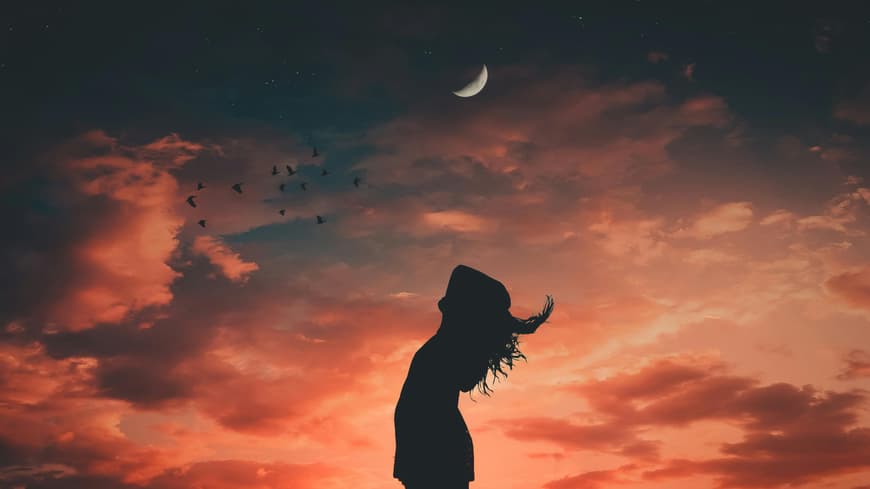 Frau steht unter dem Abendhimmel mit Mond