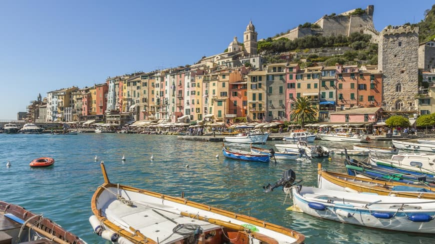 Ein Blick auf bunte Häuser und den Hafen von Portovenere mit kleinen Fischerbooten.