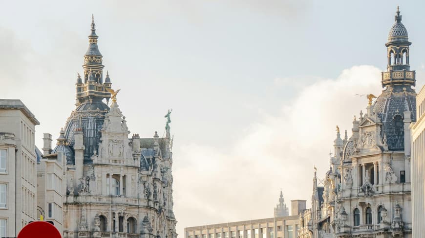 Eine Straße in Antwerpen mit hohen, alten Häusern und vielen Menschen.