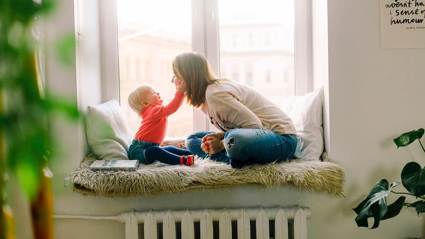 Baby hält das Gesicht einer jungen Frau