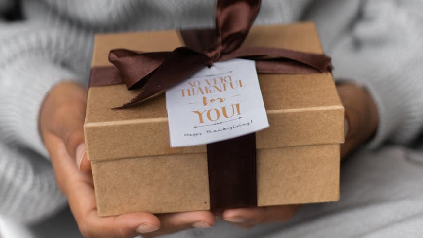 Eine Frau hält ein Geschenk in den Händen