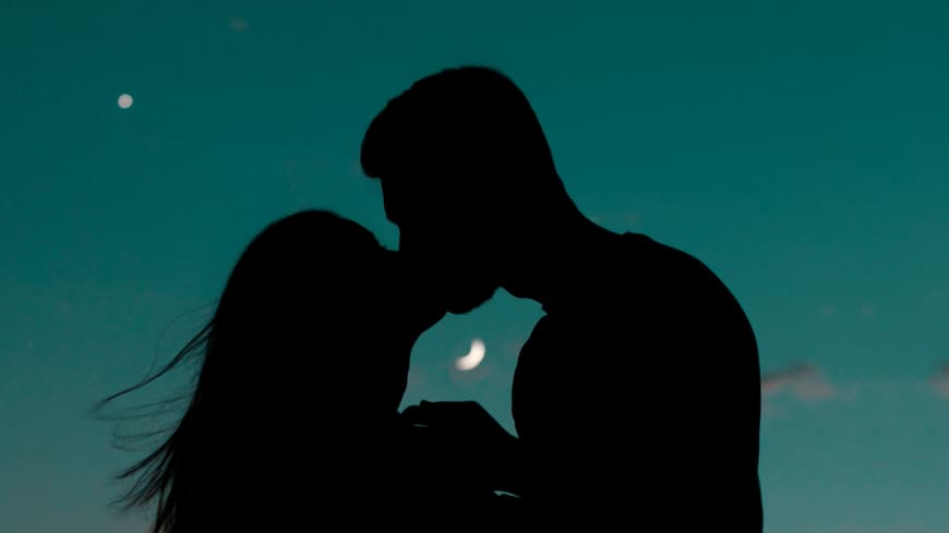 Pärchen küsst sich vor Mondhimmel