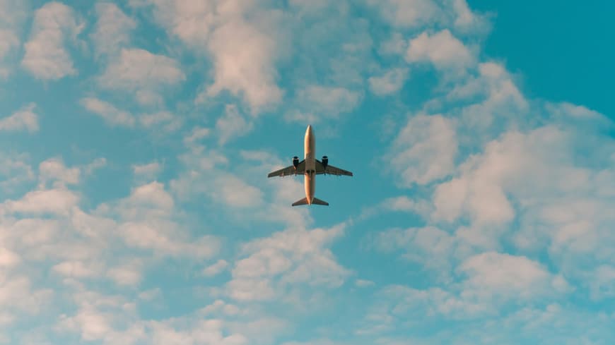 Flugzeug unter blauem Himmel mit Wolken
