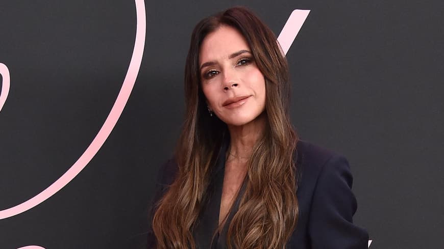 Victoria Beckham mit offenen Haaren und einem schwarzen Anzug auf dem roten Teppich.