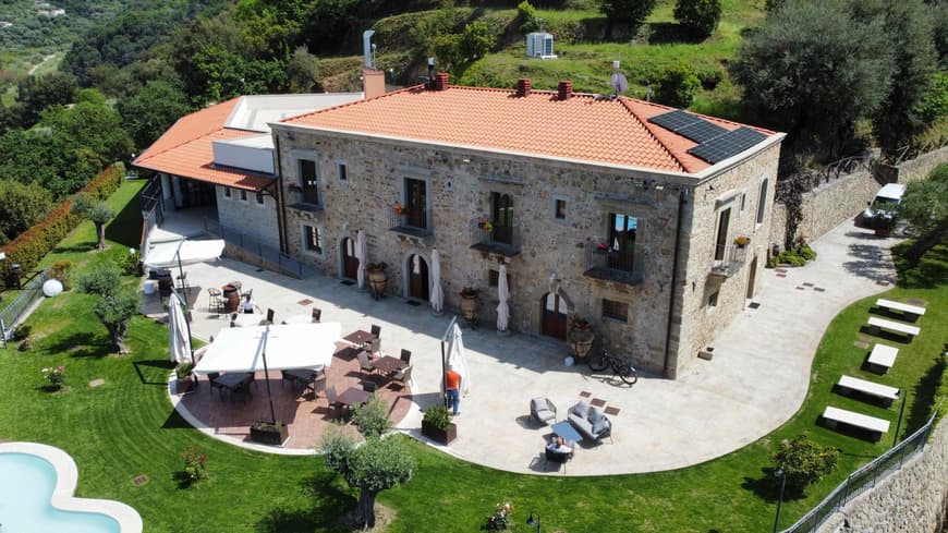 Die Villa Ginevra in Italien mit Blick von oben auf das Haus, die Terrasse und den Garten.