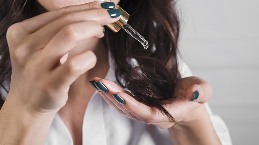 Frau trägt Haaröl auf