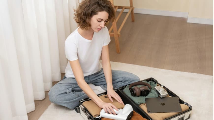 Eine junge Frau packt ihren Koffer