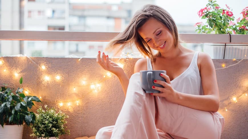 Eine Frau sitzt auf dem Balkon