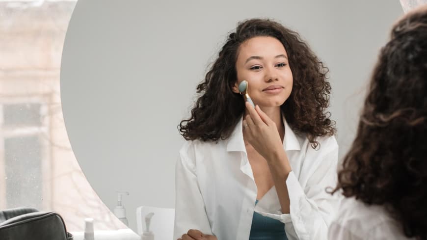 Eine Frau benutzt einen Jaderoller für ihr Gesicht