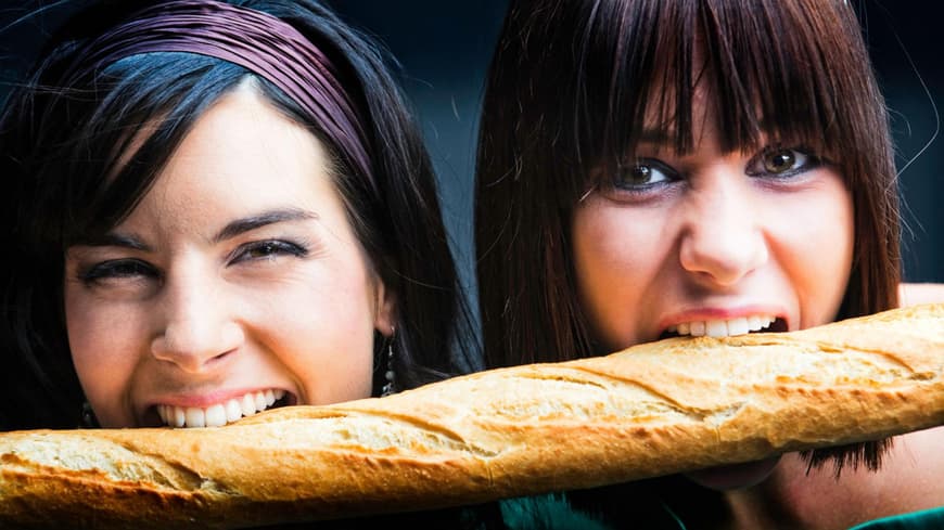 Junge Frauen beißen in Baguette