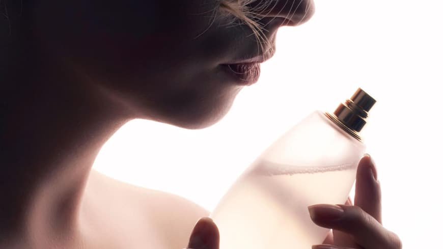 Frau riecht an Parfum