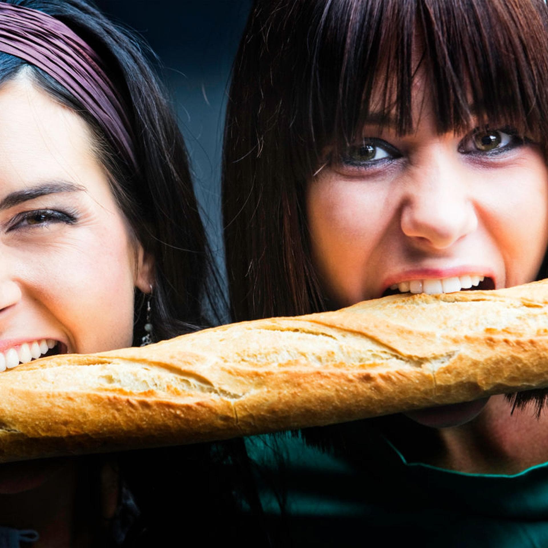 Junge Frauen beißen in Baguette Junge Frauen beißen in Baguette
