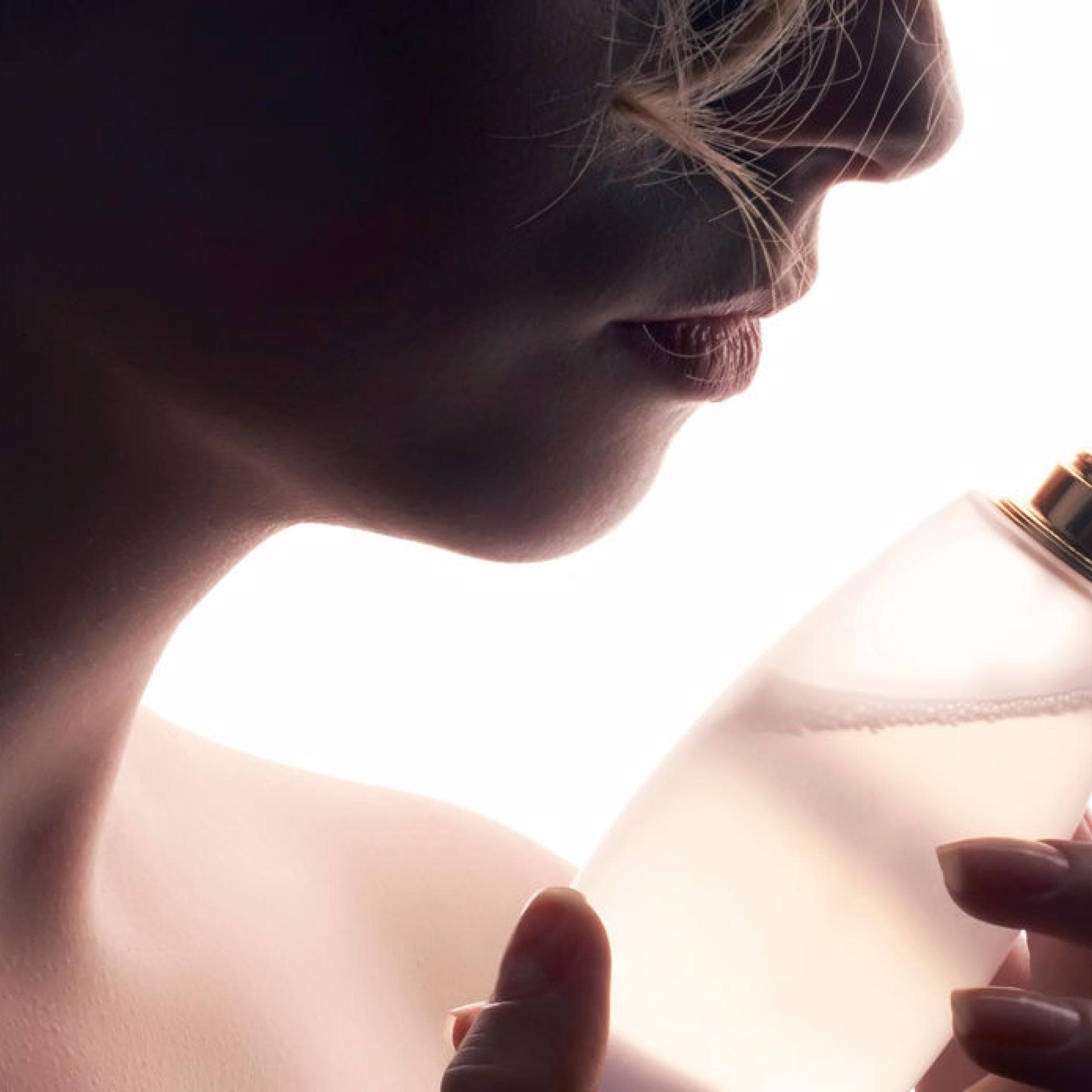 Frau riecht an Parfum