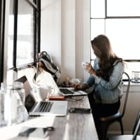 Frau sitzt am Schreibtisch und arbeitet