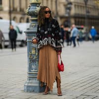 Faltenrock kombinieren: Die schönsten Looks zum nachstylen Faltenrock kombinieren: Frau im braunen Midi-Rock