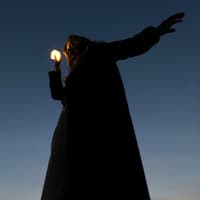 Frau hält eine kleine Lichtkugel in der Hand