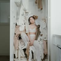 Frau im chaotischen Kleiderschrank