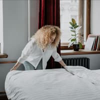 Frau macht das Bett