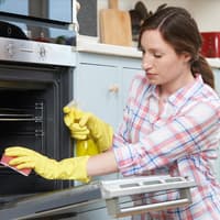 Frau putzt Backofen