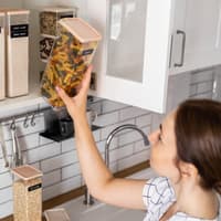 Frau sortiert ihren Küchenschrank