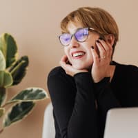 Glückliche Frau sitzt am Schreibtisch