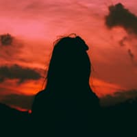 Unbeliebte Sternzeichen Silhouette einer Frau vor einem roten Himmel