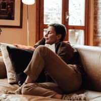 Frau sitzt entspannt auf dem Sofa