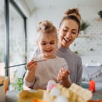 Mutter und Tochter bemalen Ostereier