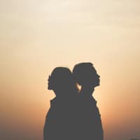 Paar steht Rücken an Rücken.