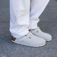 Birkenstock Boston in Grau mit einer weißen Hose kombiniert.