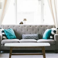 So richtest du deine Wohnung perfekt ein Grauer Sofa mit türkisen Kissen